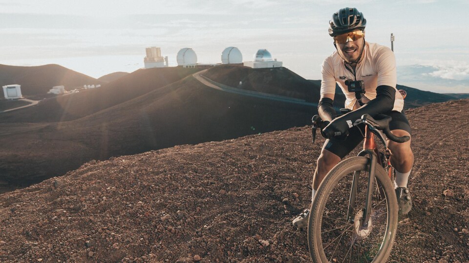 Un cycliste pose devant des observatoires astronomiques.