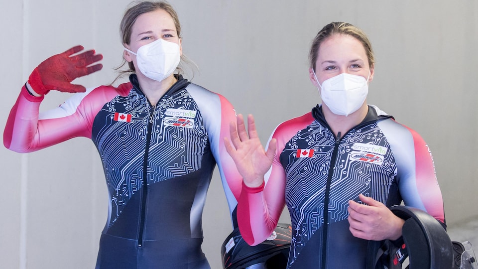 Les deux femmes dans les couleurs du Canada saluent la caméra de la main.