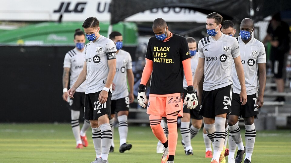 Des joueurs de l'Impact de Montréal portent un masque.