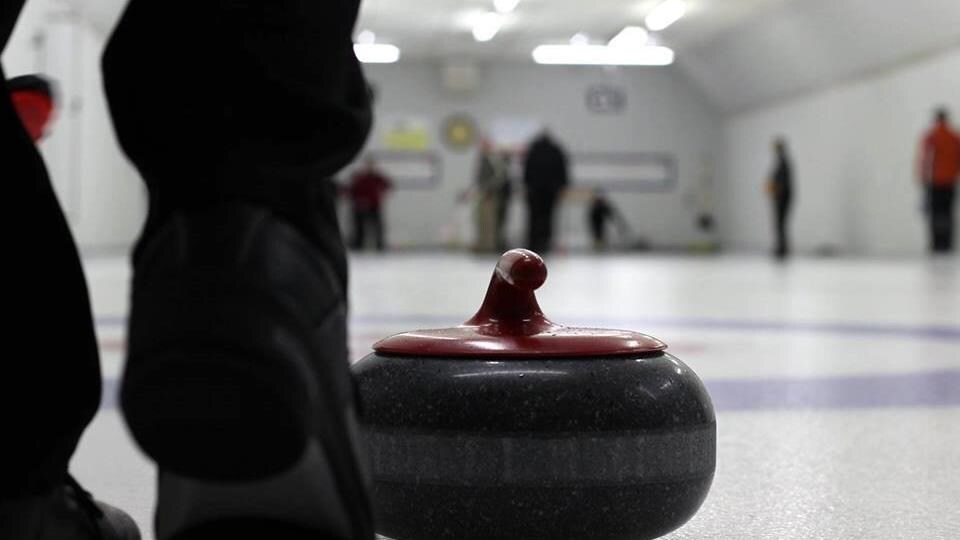 Une pierre de curling immobile sur la glace.