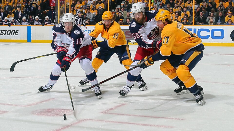 Dubois tente de protéger la rondelle, appuyé par son coéquipier Savard, face à Nashville.