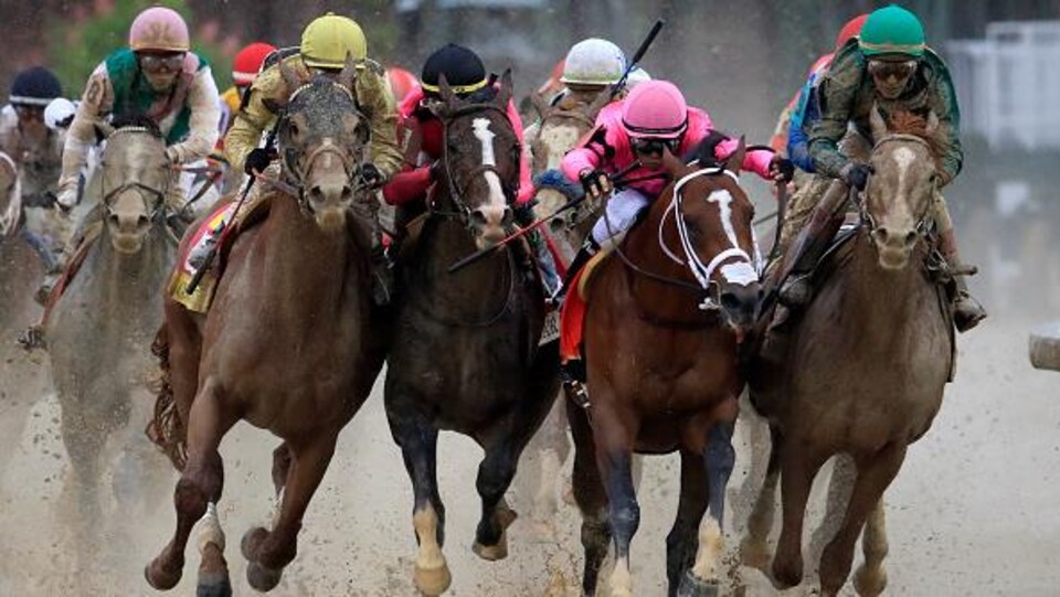 De gauche à droite, les chevaux Country House, War of Will, Maximum Security et Code of Honor au plus fort de la lutte dans le dernier virage.