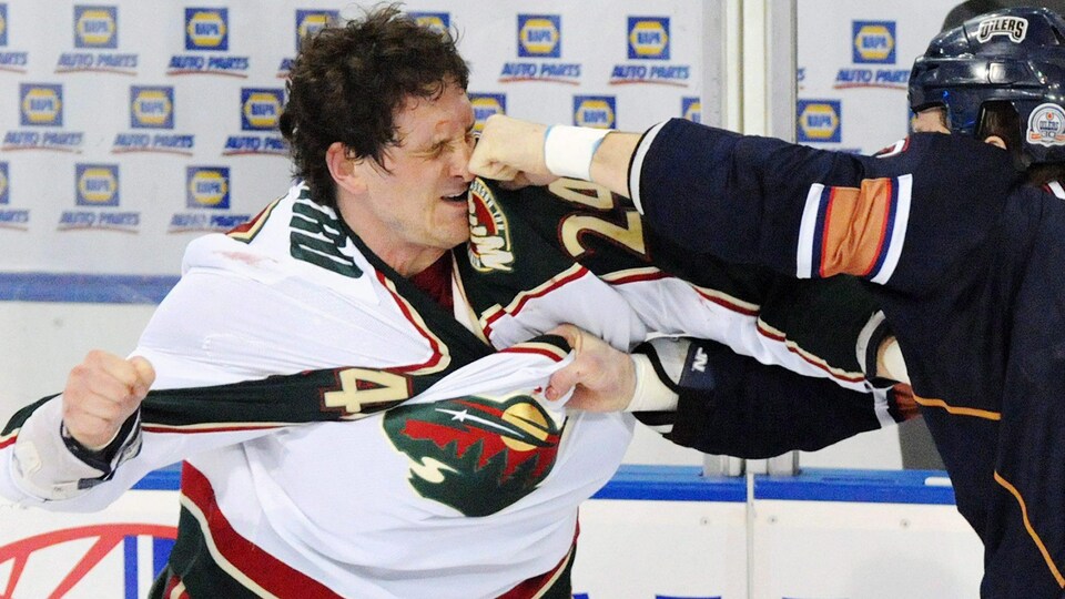 Un hockeyeur reçoit un coup de poing.