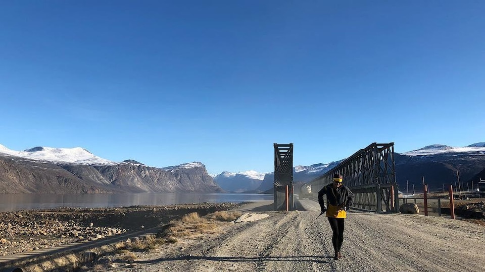 Derrick Spafford court sur une route de gravier au Nunavut.