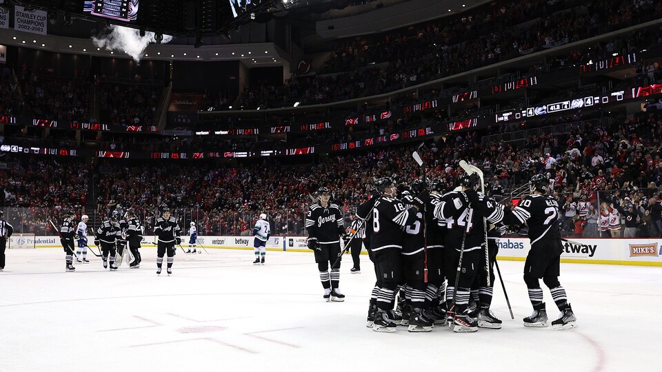 Les hockeyeurs des Devils du New Jersey se regroupent sur la patinoire pour célébrer une victoire.