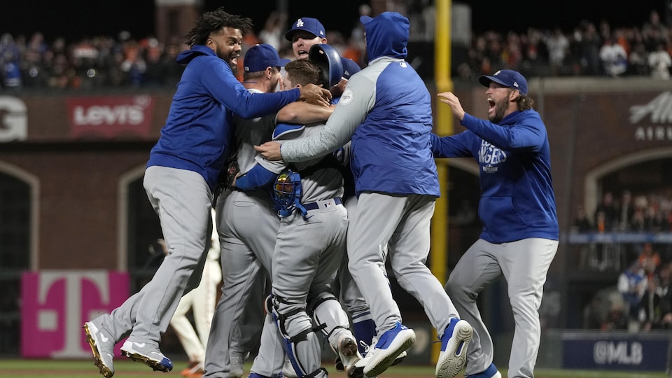 Les joueurs des Dodgers de Los Angeles se sautent dans les bras après leur victoire contre les Giants de San Francisco.