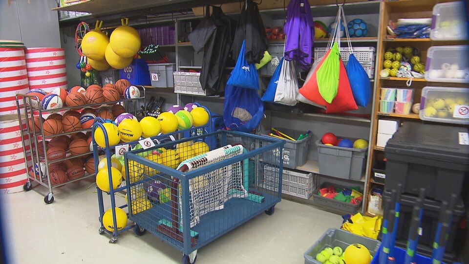 Des ballons et de l'équipement d'éducation physique dans l'entrepôt d'un gymnase.