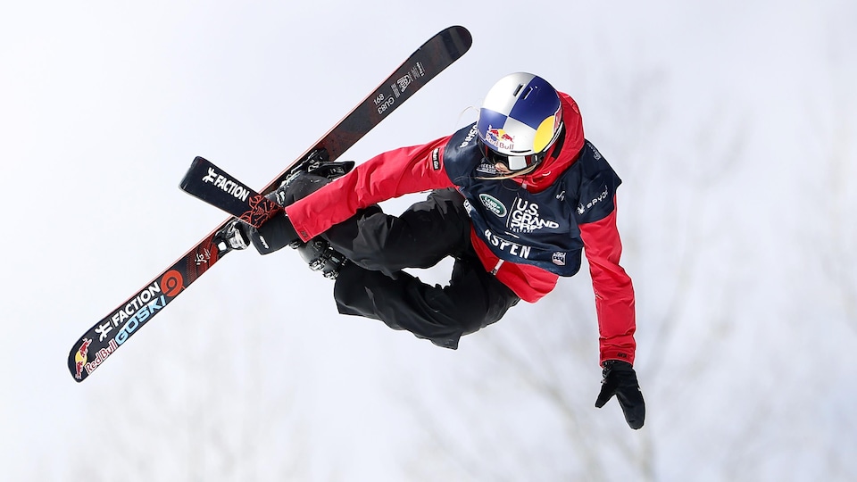 Une skieuse effectue une manœuvre dans les airs.