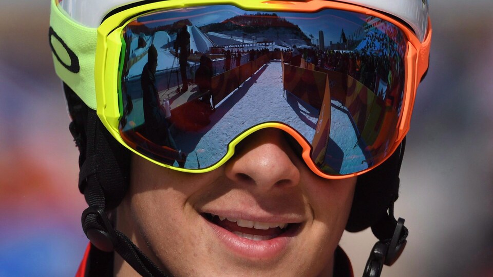 Gros plan d'un homme avec des lunettes et un casque de course