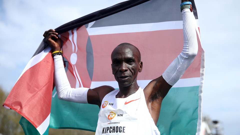 Il tient un drapeau du Kenya.