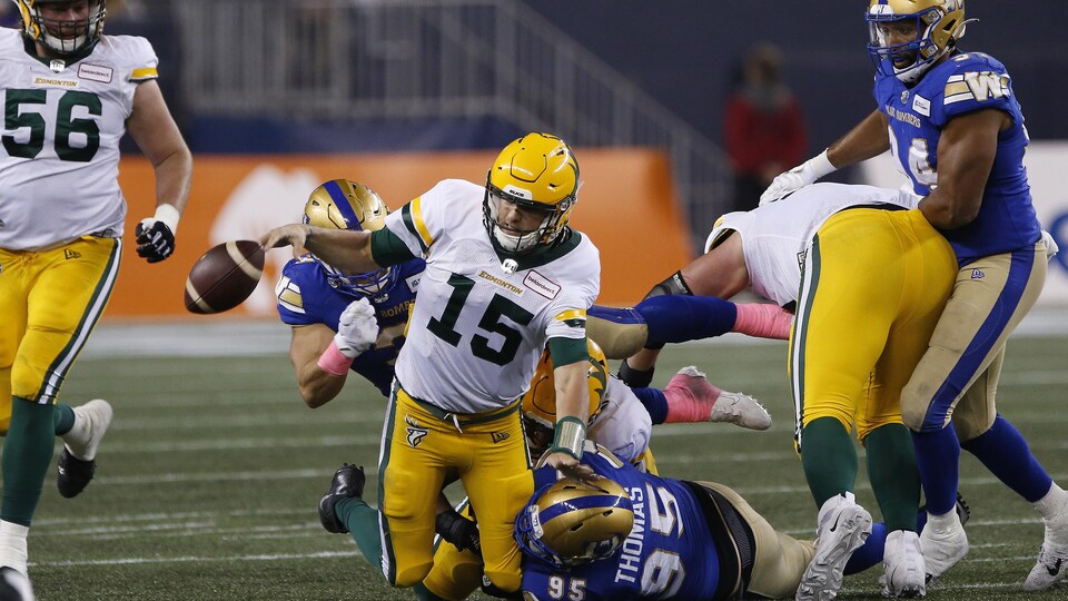 Le quart-arrière des Elks aylor Cornelius est plaqué par Jake Thomas des Blue Bombers de Winnipeg.