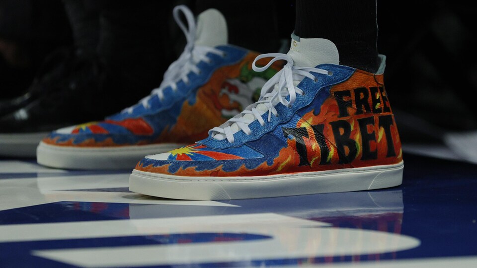 Des souliers bleus et orange avec l'inscription Free Tibet.