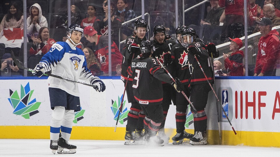 Des hockeyeurs canadiens se regroupent après un but devant un rival finlandais.