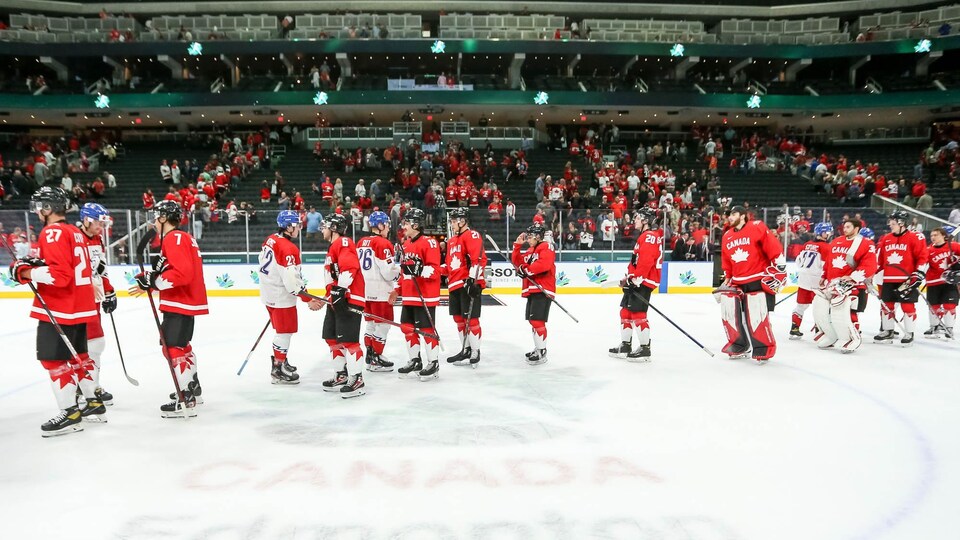 Des hockeyeurs canadiens et tchèques se serrent la main après un match.