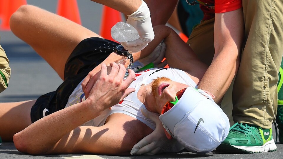 Après s'être écroulé à l'arrivée du 50 km des Jeux de Rio en 2016, le Canadien Evan Dunfee, 4e, reçoit de l'eau des officiels.