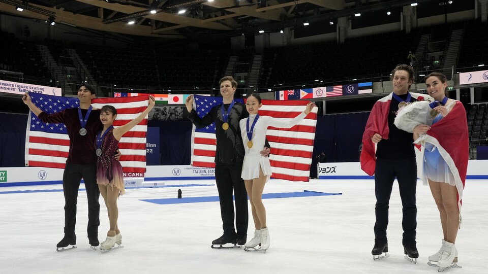Les trois couples gagnants s'enveloppent du drapeau de leur pays.