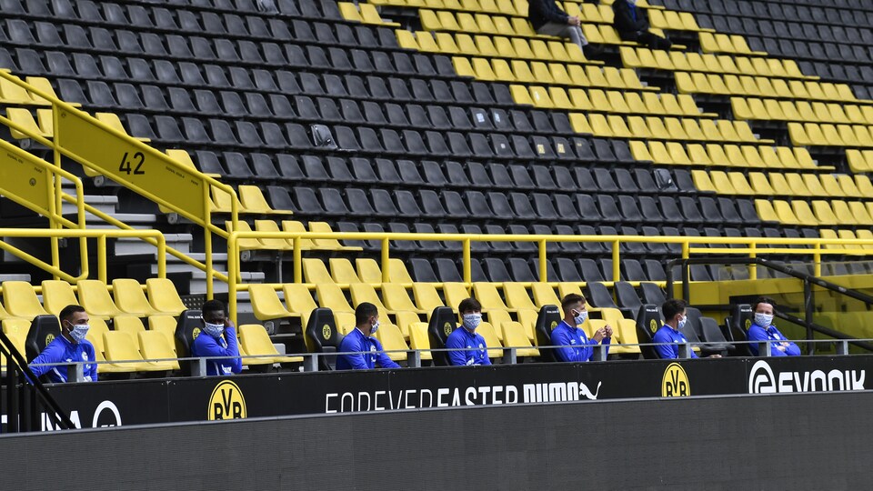 Les joueurs du FC Schalke 04 sont sur le banc à une distance de 1,5 m.