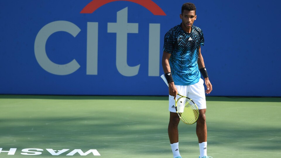 Le joueur de tennis regarde de l'autre côté du terrain, l'air quelque peu abattu, après avoir perdu un échange.