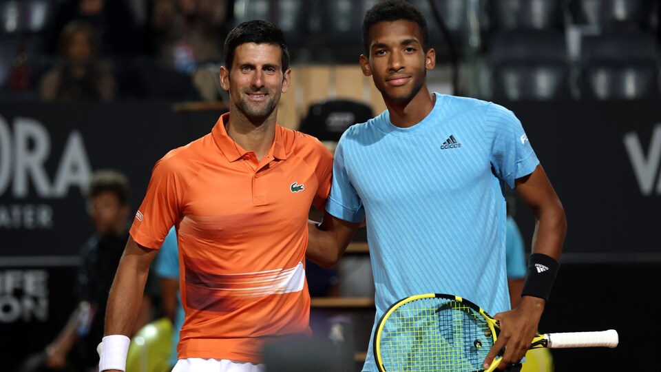 Les deux joueurs de tennis prennent la pose près du filet. 