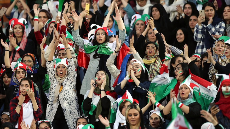 Des femmes applaudissent leur équipe, dont elles portent les couleurs.