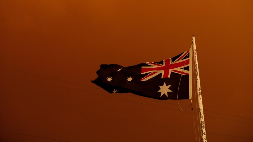 Le drapeau australien vole dans un épais nuage de fumée.