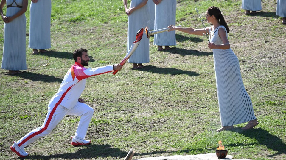 L'actrice grecque Xanthi Georgiou allume le flambeau tenu par le skieur grec Giannis Antoniou.