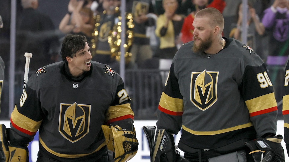 Les deux gardiens, portant leur équipement sauf leur casque, se regardent en souriant pendant un échauffement durant la série contre le Wild du Minnesota.