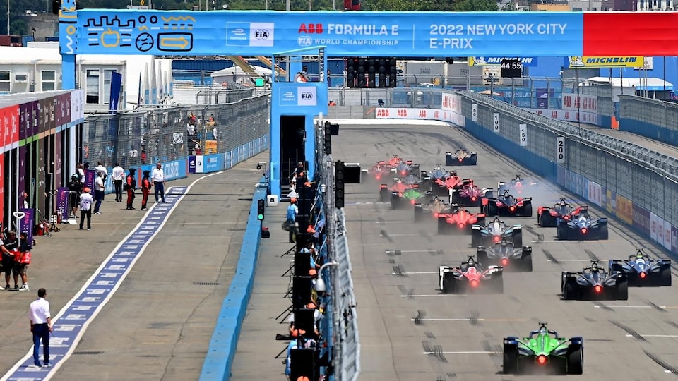 From the back, single-seaters from the Formula E Championship drive on a circuit. 