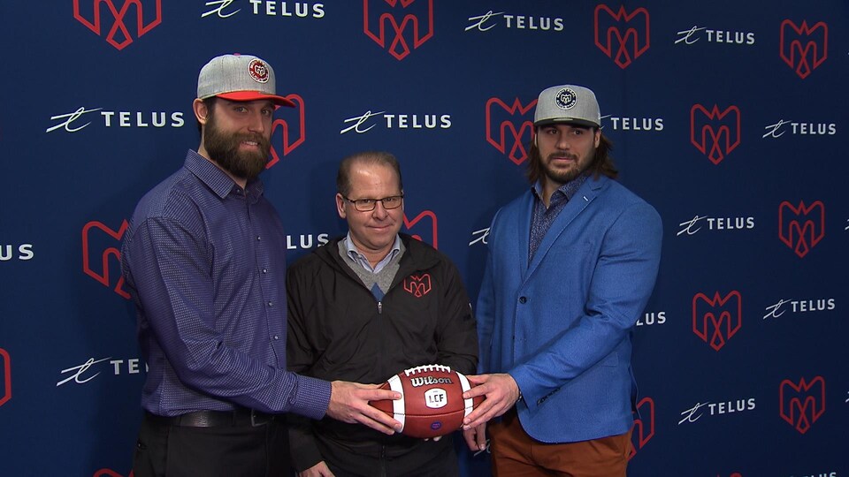 Ils tiennent un ballon de football.