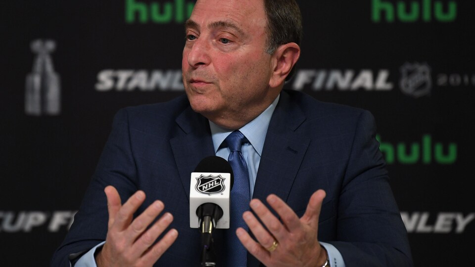 Bettman devant un panneau affichant notamment le logo de la LNH et de Hulu.