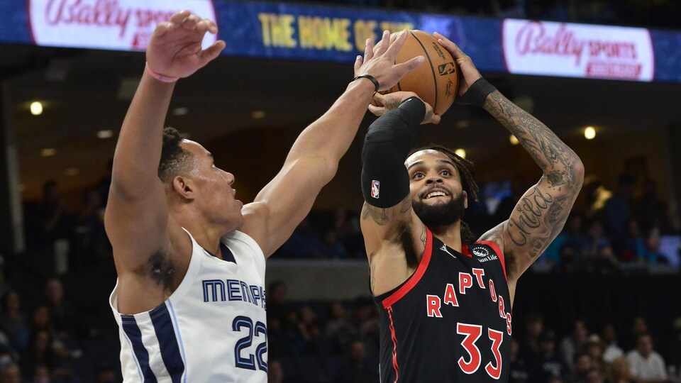 Le garde de Toronto, en noir, s'apprête à tirer alors qu'un adversaire essaie de le bloquer.