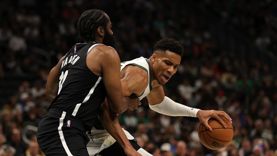Le ballon dans sa main gauche, le joueur des Bucks tente de déjouer celui des Nets.