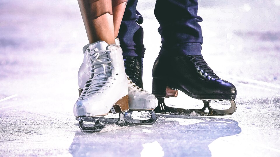 Les patins d'un couple de patineurs sur la glace.