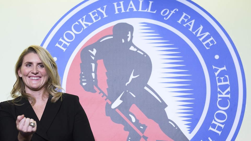 Hayley Wickenheiser pose devant le logo du Temple de la renommée du hockey à Toronto 
