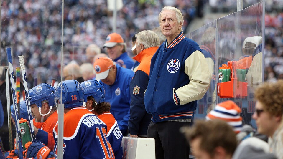 John Muckler, debout derrière le banc des Anciens Oilers à la Classique Héritage, en octobre 2016