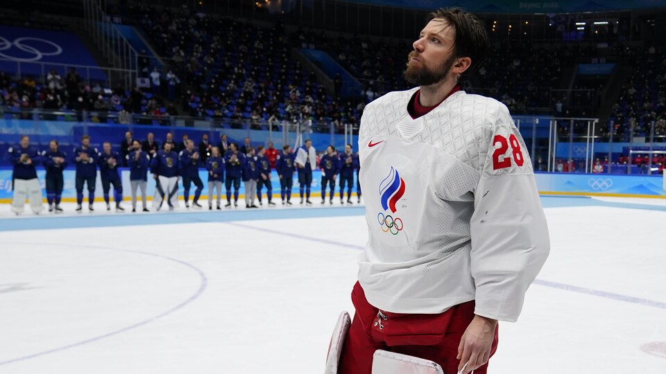 Il regarde vers le haut sans son masque sur la glace.