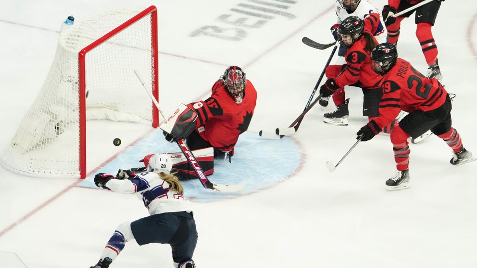 Une hockeyeuse lance au filet, mais touche le poteau.