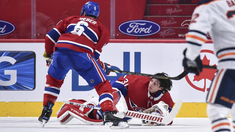 Un gardien sans masque est étendu sur la glace.