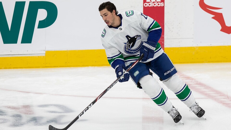 Le hockeyeur patine sur la glace sans son casque.