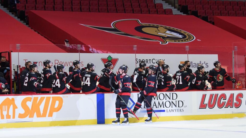 Devant des gradins vides, Thomas Chabot reçoit les félicitations de ses coéquipiers au banc des siens.