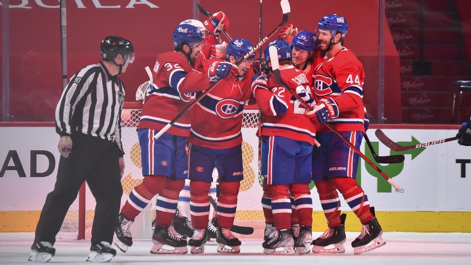 Des joueurs en rouge célèbrent un but.