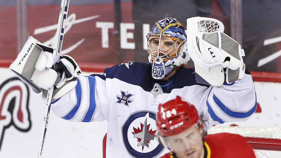 Le gardien lève les bras pour célébrer la victoire devant son filet.