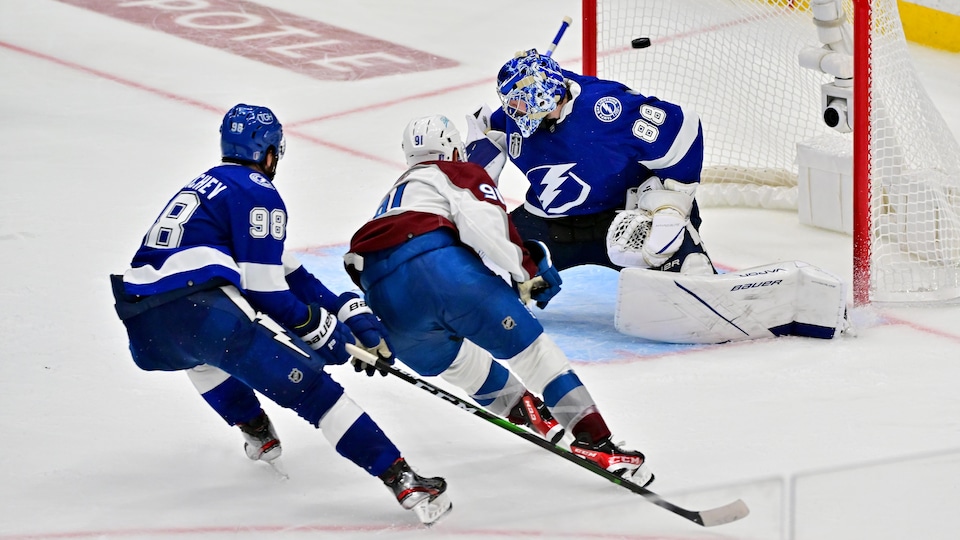 Un joueur de hockey marque un but.