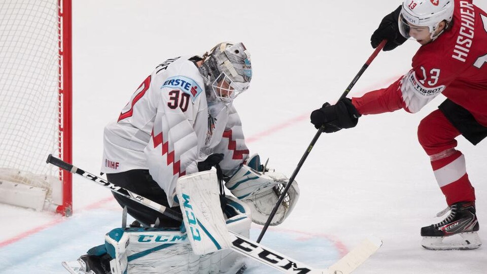 Nico Hischier avec l'équipe de Suisse, tentant de marquer un but.