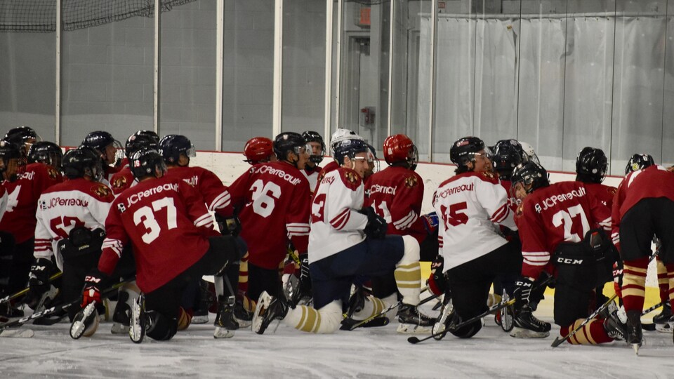 Des hockeyeurs du programme de hockey Ulysse ont un genou posé au sol.