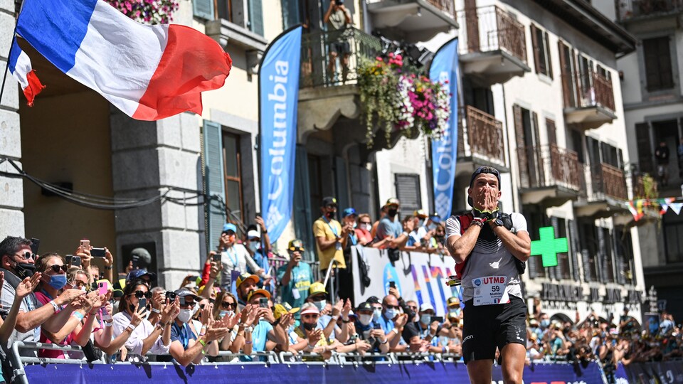 Le coureur se couvre le visage à l'arrivée.