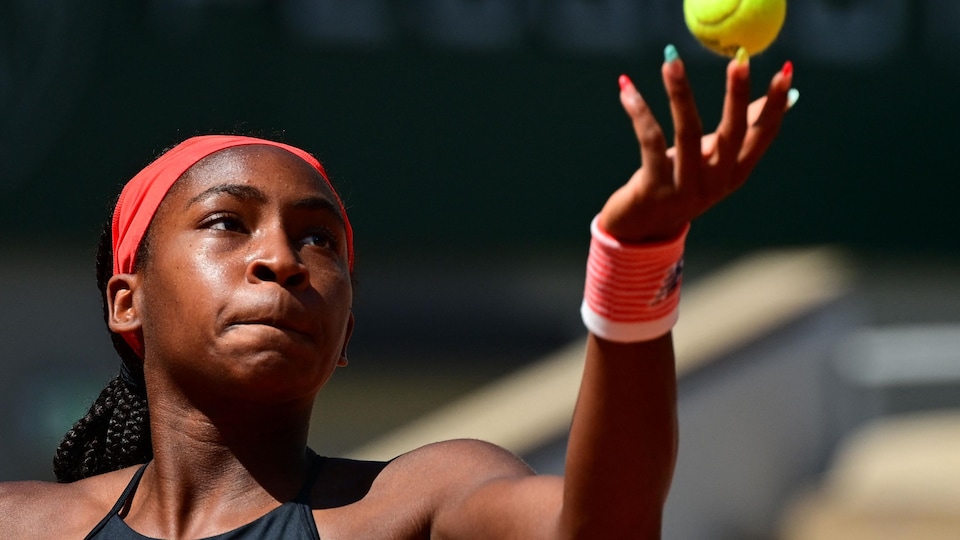 La joueuse de tennis lance la balle.