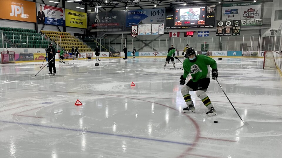 Des joueurs de hockey manient la rondelle pendant un exercice.
