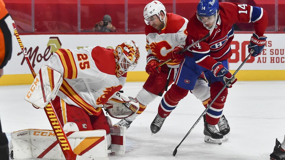 Le gardien des Flames arrête le tir du joueur du Canadien.
