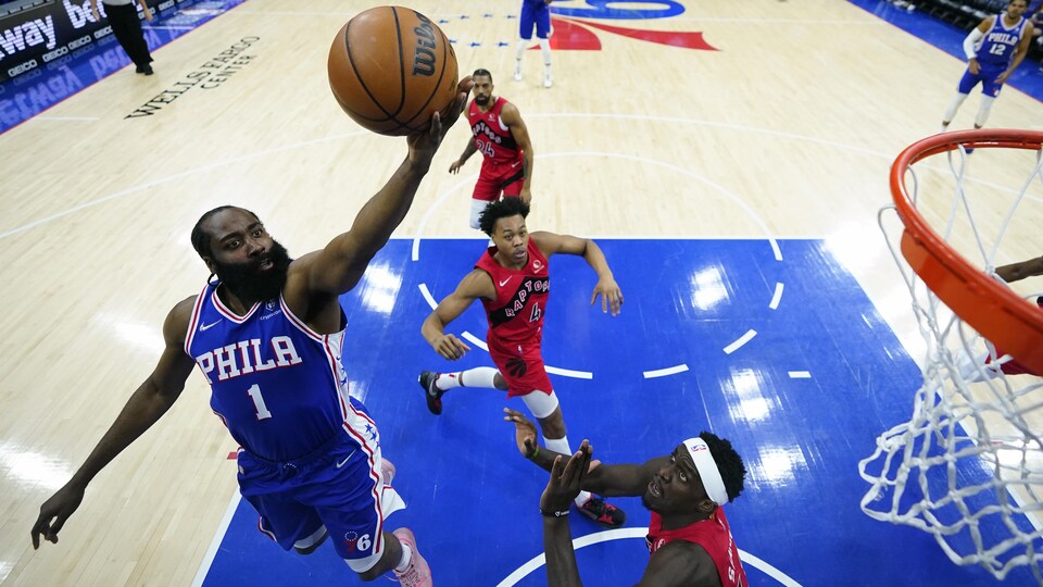 James Harden was carrying a basketball on the hoop as he jumped into the air while Pascal Siakam of the Raptors watched.